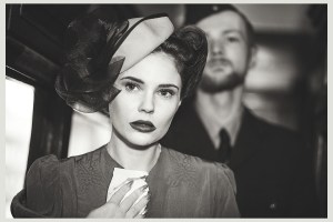 1940s model holding tissue walks down train with RAF pilot behind her